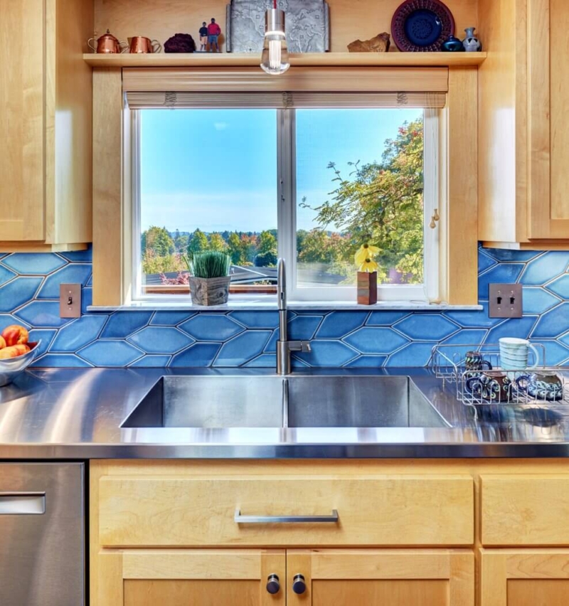 dramatically vibrant kitchen remodel Stainless steel countertops and integrated stainless sink make this kitchen design a real stand out