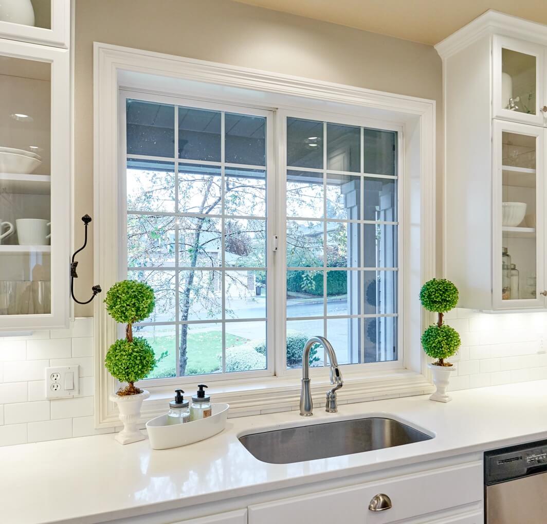 Caesarstone countertops and a white subway tile backsplash complete the look in this white schoolhouse kitchen.