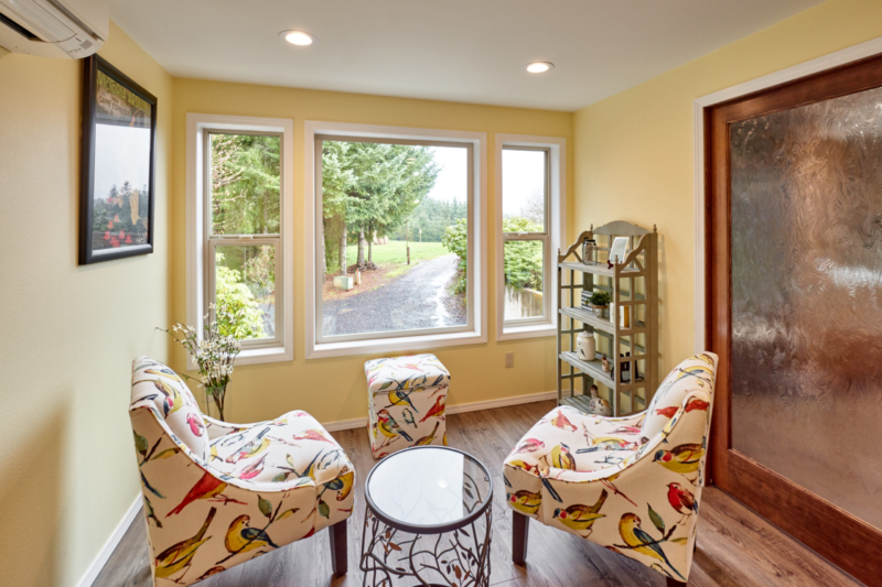 sitting are with large windows and yellow walls 