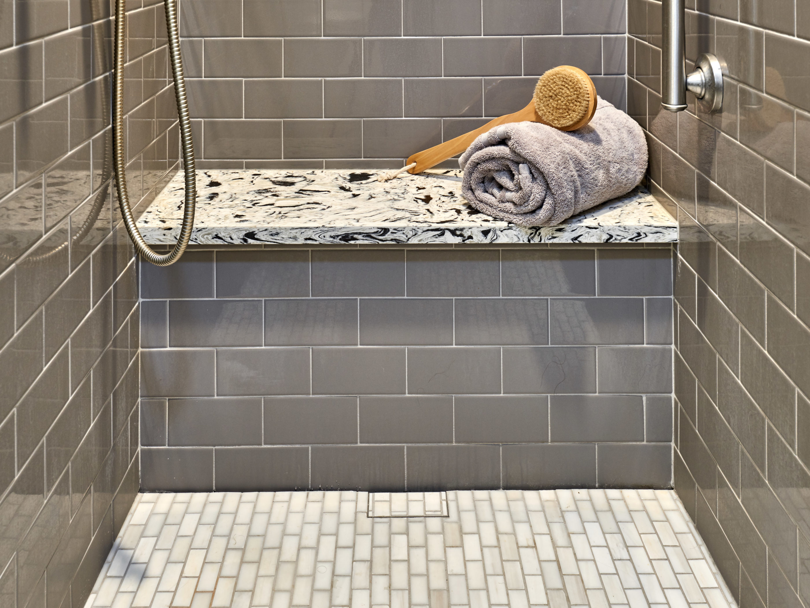 bench in gray shower with quartz on top for seating 