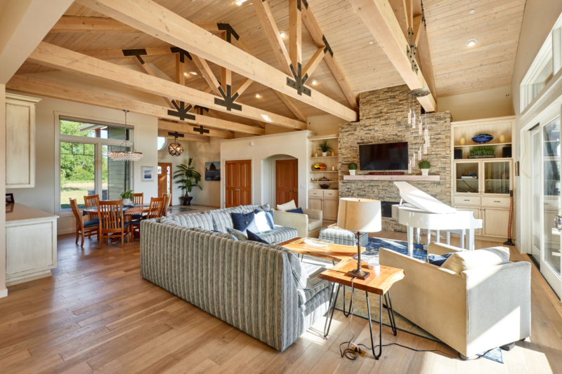 timber beams above hardwood floors and masonry stone fireplace 