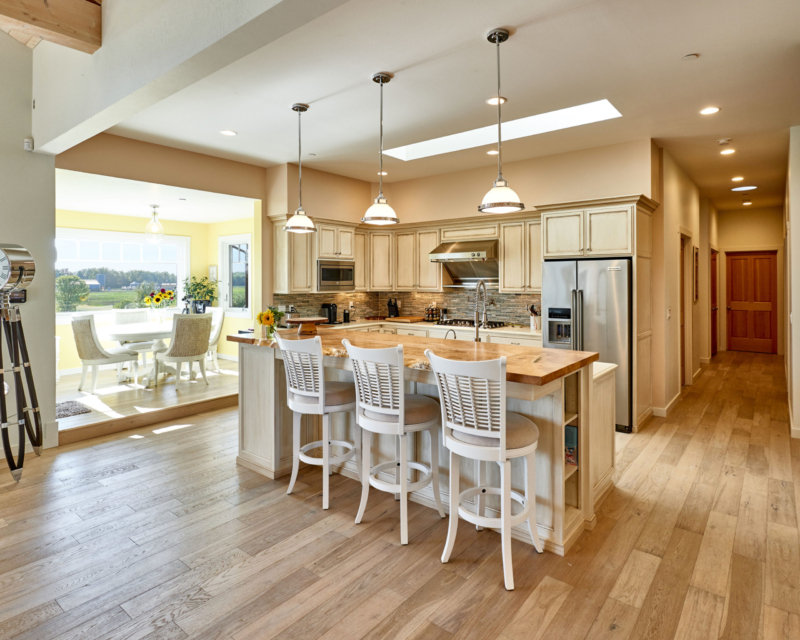 kitchen island with white chairs and light cabinets 