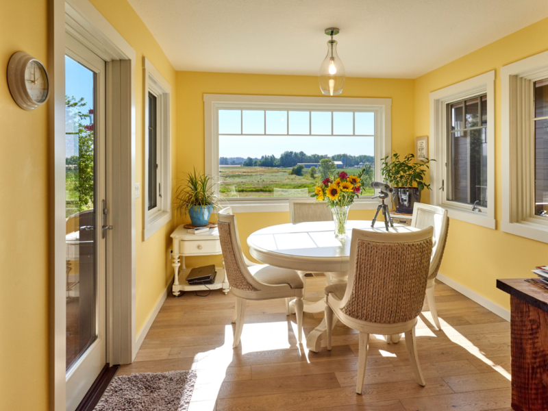 dining area with bright yellow walls and white dining furniture 
