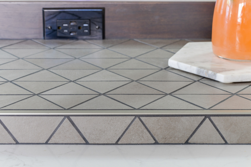 Gray trapezoid accent tile on island 
