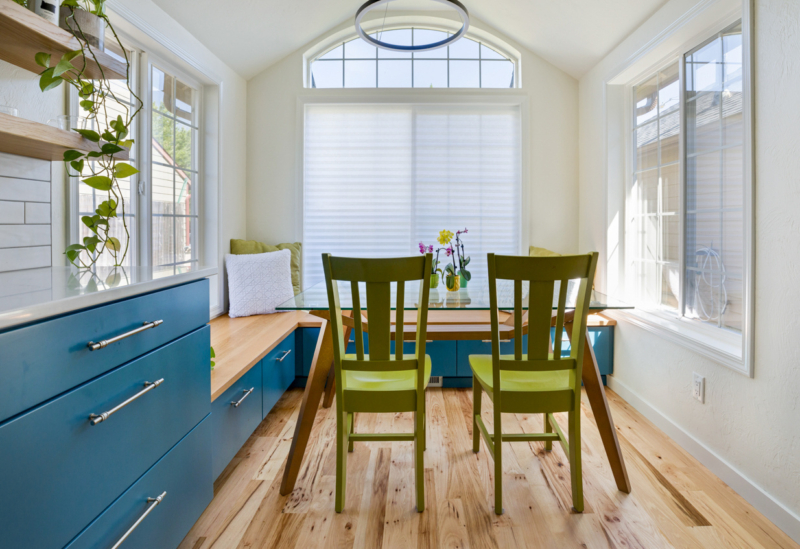 breakfast nook with blue cabinets and green chairs 