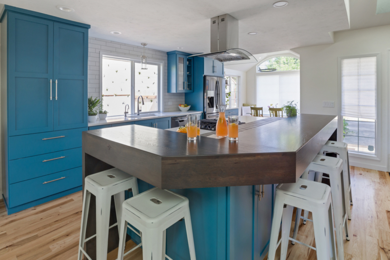 Blue cabinets under kitchen island with white bar stools