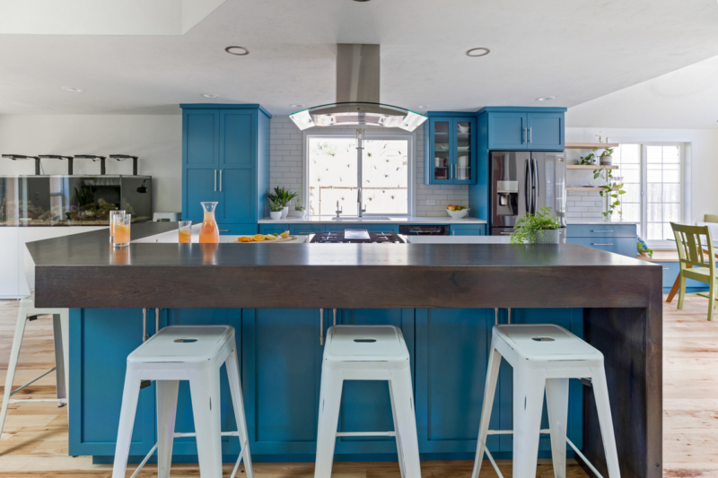 blue cabinets in kitchen with island and stools