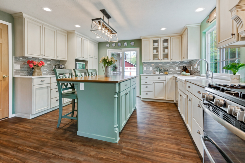 Bright kitchen with a teal island and bar stools