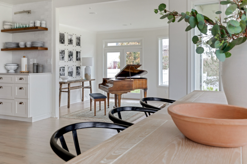 View from dining room table into room housing antique piano
