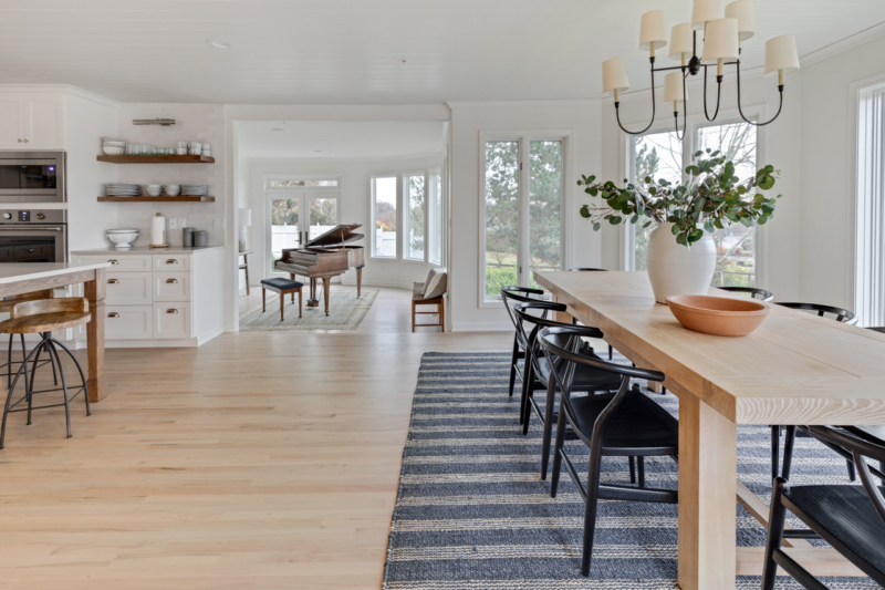 Overall view of dining space with blue striped rug and contemporary chandelier
