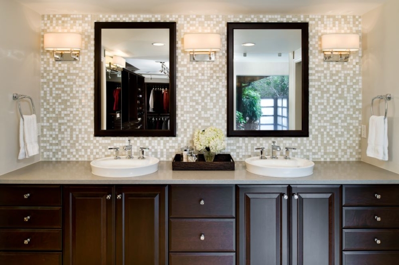 White Kohler semi-vessel sinks on the dark wood vanity create an exquisite contemporary look.
