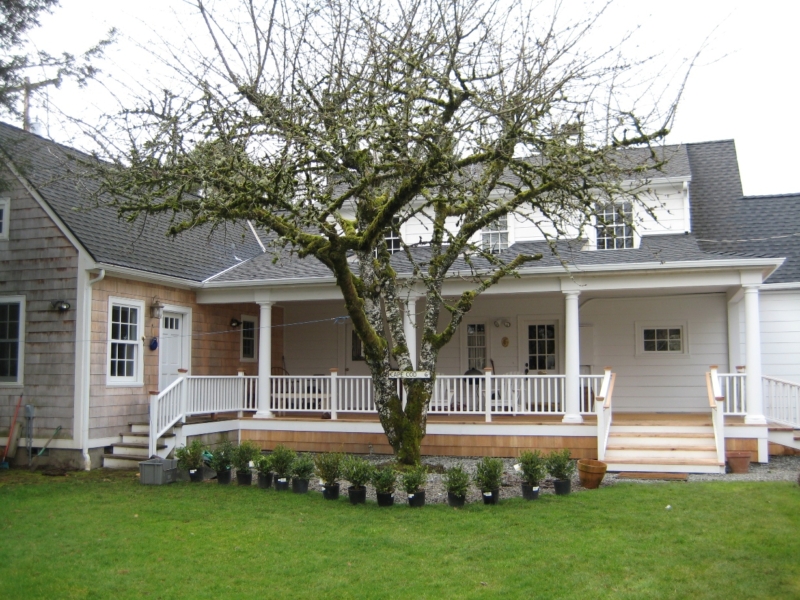 A back porch with integrated roof and cedar decking replaces the old concrete slab. A back porch with integrated roof and cedar decking replaces the old concrete slab.