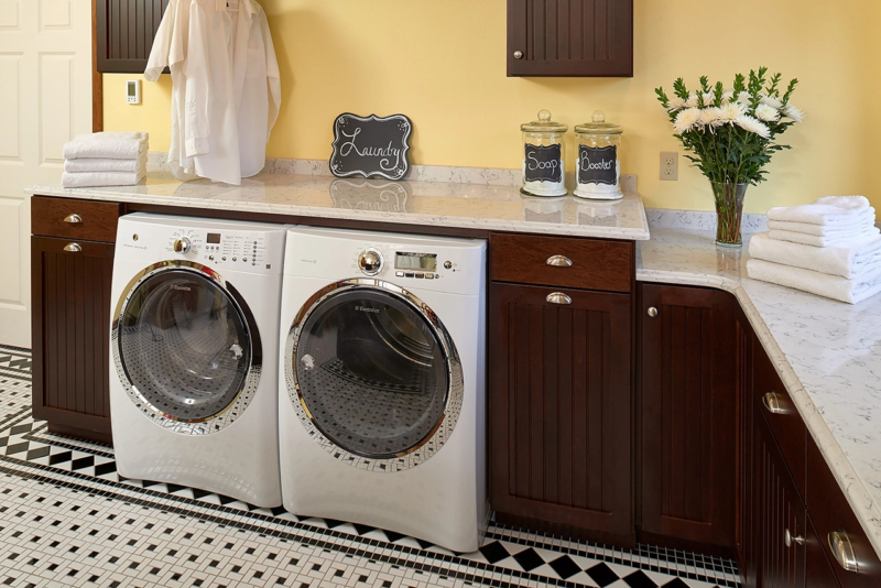 A yellow laundry with dark stained cabinets. A yellow laundry with dark stained cabinets.