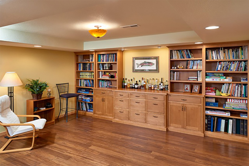 This basement retreat has a coffered ceiling and built-in cabinetry for both a bar and game/book storage. White schoolhouse style home exterior