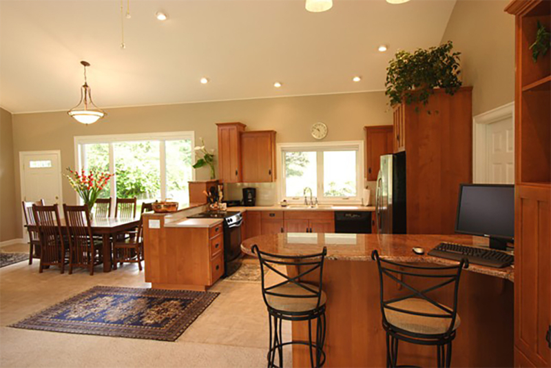 A granite bar divides the living and kitchen areas can work as a computer center or bar for entertaining. Construction team raising roof trusses