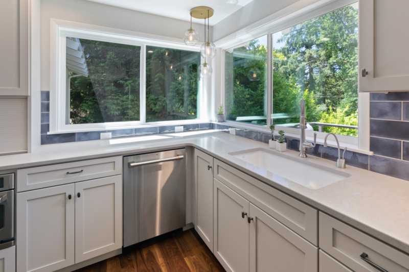 Large corner windows over the sink provide a gorgeous view for these homeowners. Large corner windows over the sink provide a gorgeous view for these homeowners.