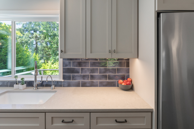 Textured, dark blue backsplash adds a pop of color in this kitchen. Textured, dark blue backsplash adds a pop of color in this kitchen.