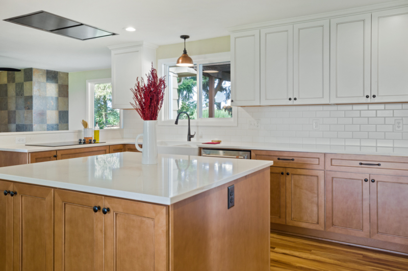 Large island with stained wood and quartz countertops.
