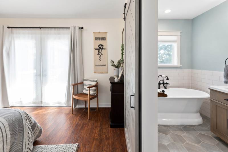 Barn door separates primary bath from bedroom Barn door separates primary bath from bedroom