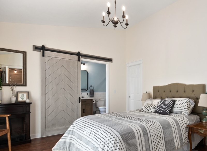 Modern Farmhouse master bedroom with vaulted ceiling, barn doors into ensuite bathroom by Powell Construction Corvallis residential exterior view