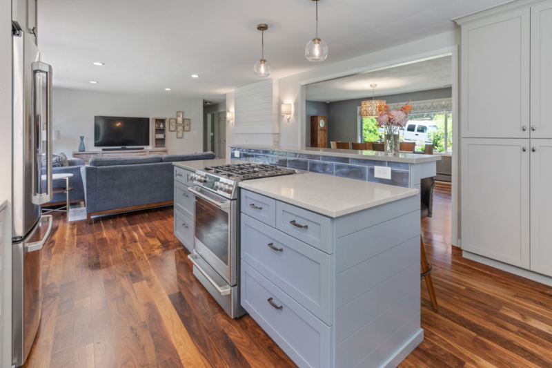 Large island with range and bar seating in kitchen remodel by Powell Construction.