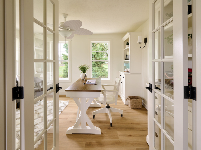 Lovely french doors leading into new home office Sunny living room with large windows and light decor