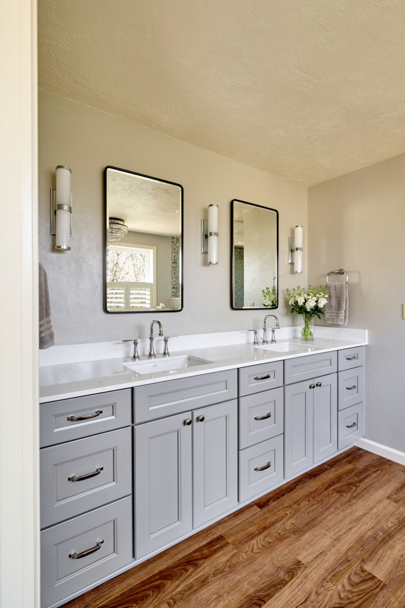 Double vanity with quartz countertop and chrome fixtures. Photo of a gray, double vanity with quartz countertops and modern vanity lights.