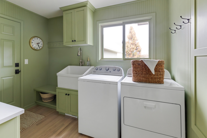 Washer and dryer in green laundry room. Full-height wainscotting adds interest to this design. Washer and dryer in green laundry room. Full-height wainscotting adds interest to this design.
