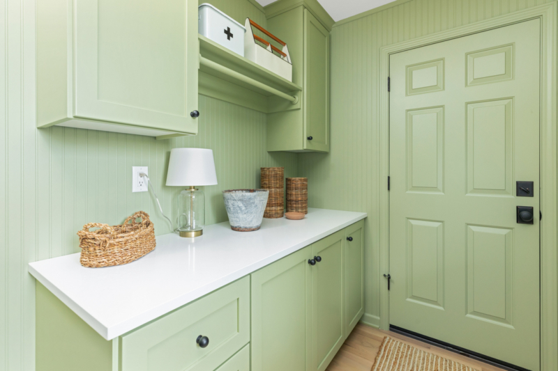 Green farmhouse laundry room with white countertops by Powell Construction Laundry Room Remodel by Powell Construction