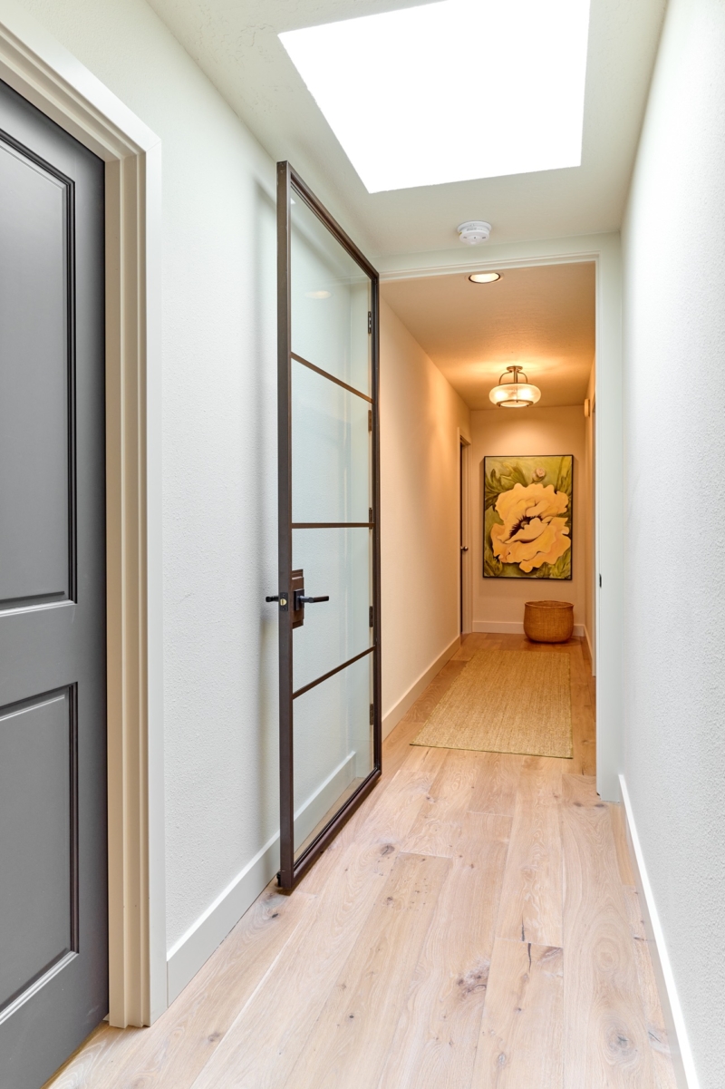 Modern bronze door creates vestibule Modern bronze door creates vestibule to primary suite by Powell Construction