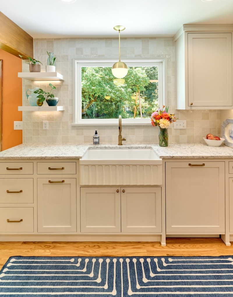 Warm greige cabinetry and fluted apron sink in this mid-century meets modern remodel by Powell Construciton Warm greige cabinetry and fluted apron sink