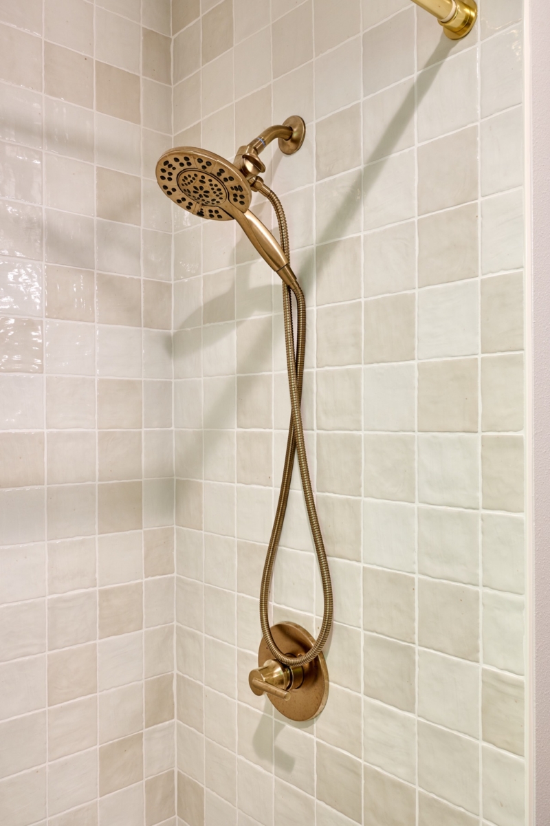 Brushed gold bath fixtures are a statement of luxury in this bathroom remodel by Powell Construction