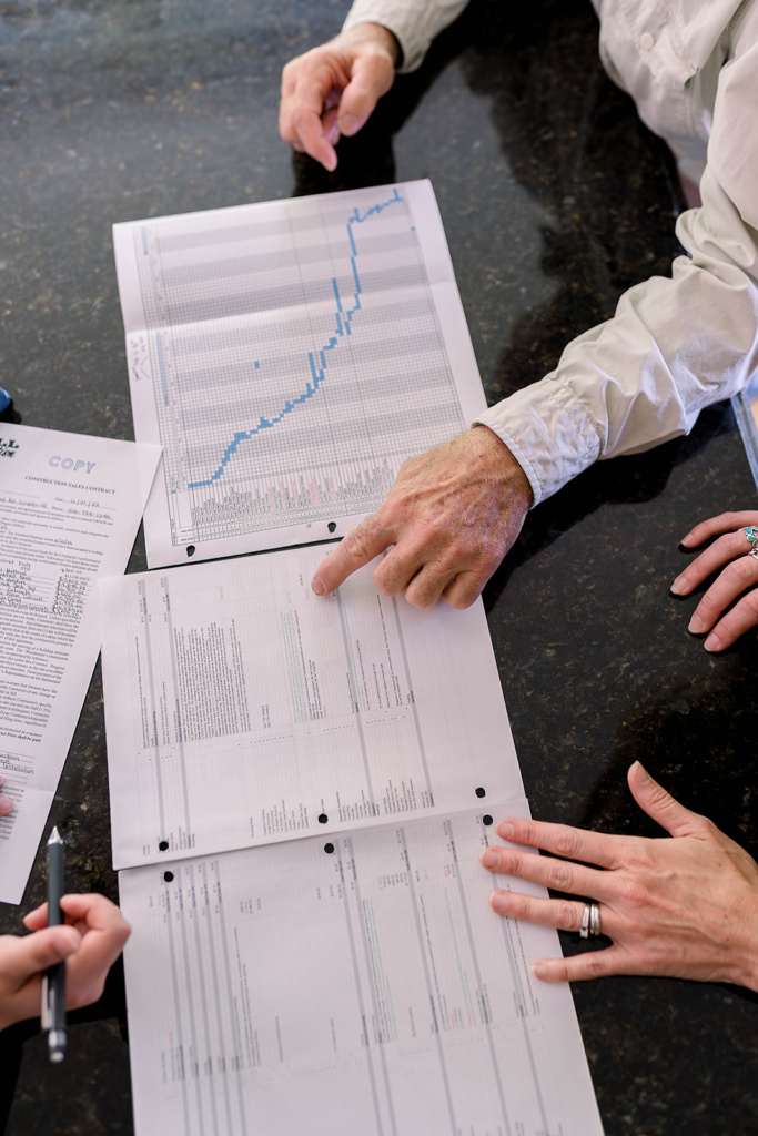 Reviewing the details of the construction estimate and schedule with the customer.