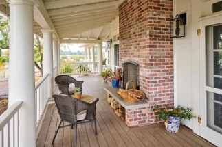 Front porch with exterior brick fireplace and seating area.