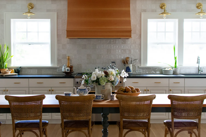 Custom Range Hood Glossy, white, zellige tile is kitchen backsplash from counter to ceiling.