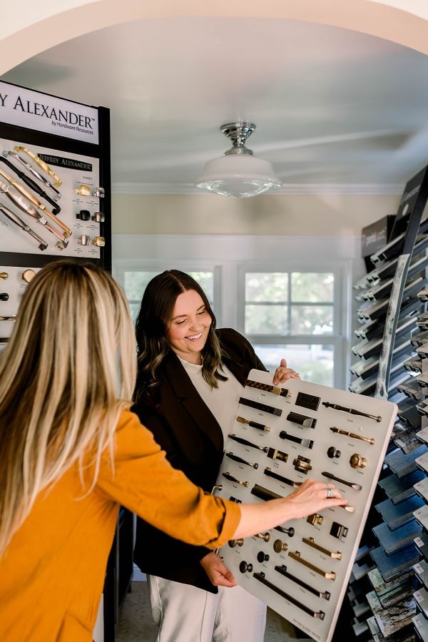 A Powell Construction designer helping a customer select cabinet hardware for her remodeling project.