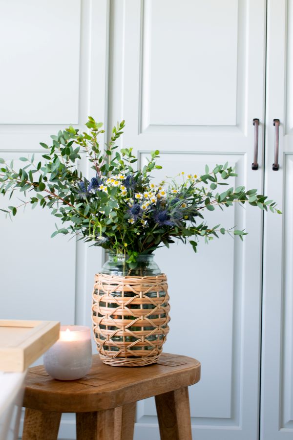 Bathside stool with greenery and a lit candle for a spa-like touch.