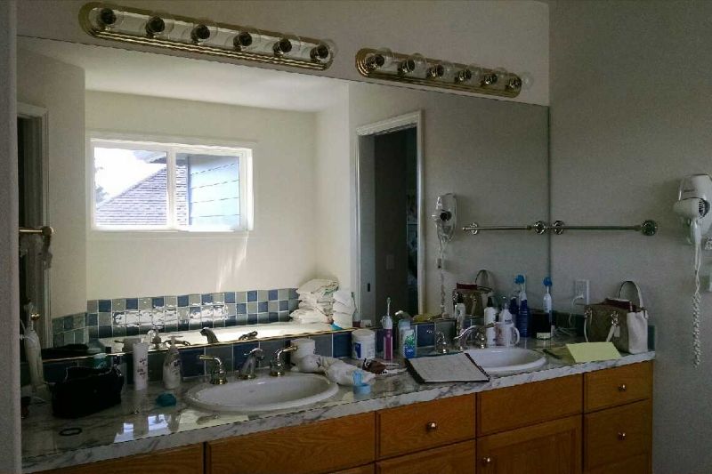 Bathroom vanity with blue tile backsplash. This bathroom was dark with tired finishes prior to remodel.