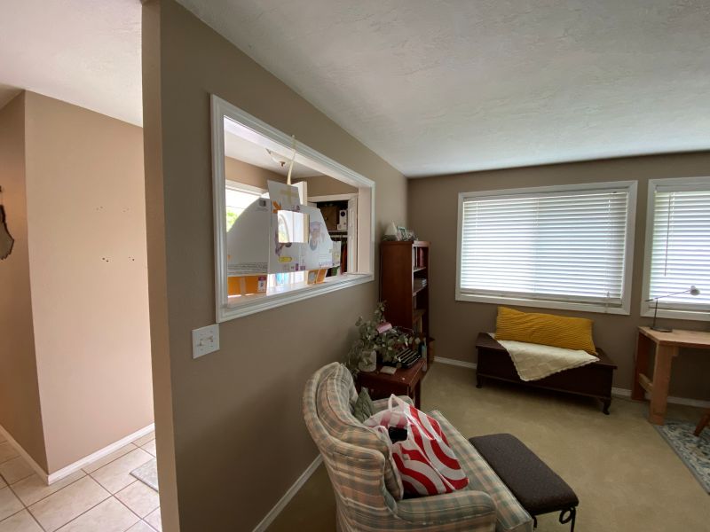 Small entry way and living room separated by a wall, prior to the remodel that increased the space and appeal of the entry, while creating a gorgeous home office.