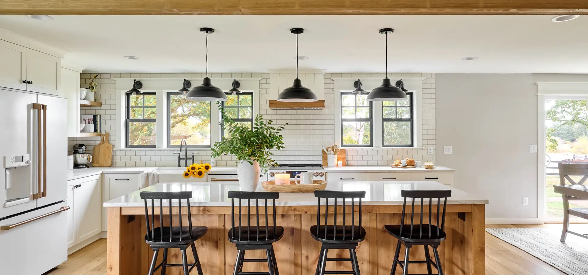 Modern farmhouse kitchen remodel with classic white subway tile and matte black pendants over the island.