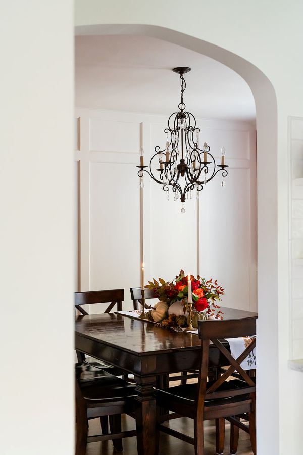 Coffee table centerpiece of florals and greenery in focus, with a historic wood-surround fireplace visible in the background.