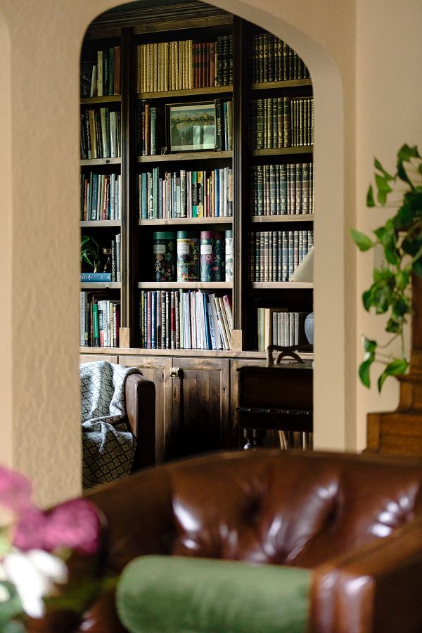 View from living room through arched doorway into study with custom built-in bookcases.