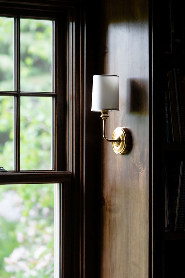 Close up of brass wall sconce in library reading nook.