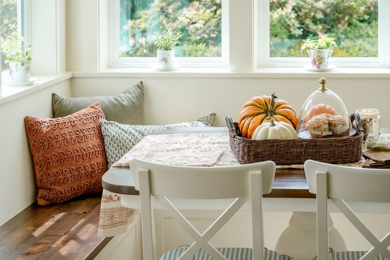 Cozy dining area with a built-in banquette, wooden benches, and a matching custom wood table.