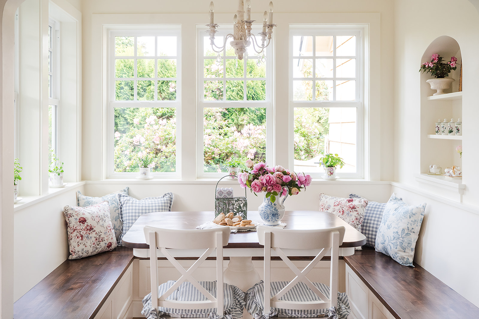 Built-in breakfast nook surrounded by windows with garden view.