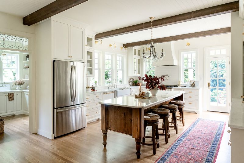 Open-concept English cottage kitchen with traditional details, adjacent to a quaint butler’s pantry.