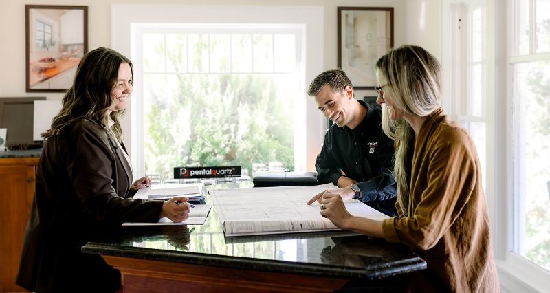 Designer and Project Coordinator meeting with a customer to discuss the details of her upcoming remodeling project.