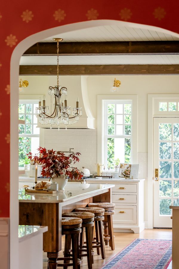 Archway from dining room into english cottage style, warm white kitchen.