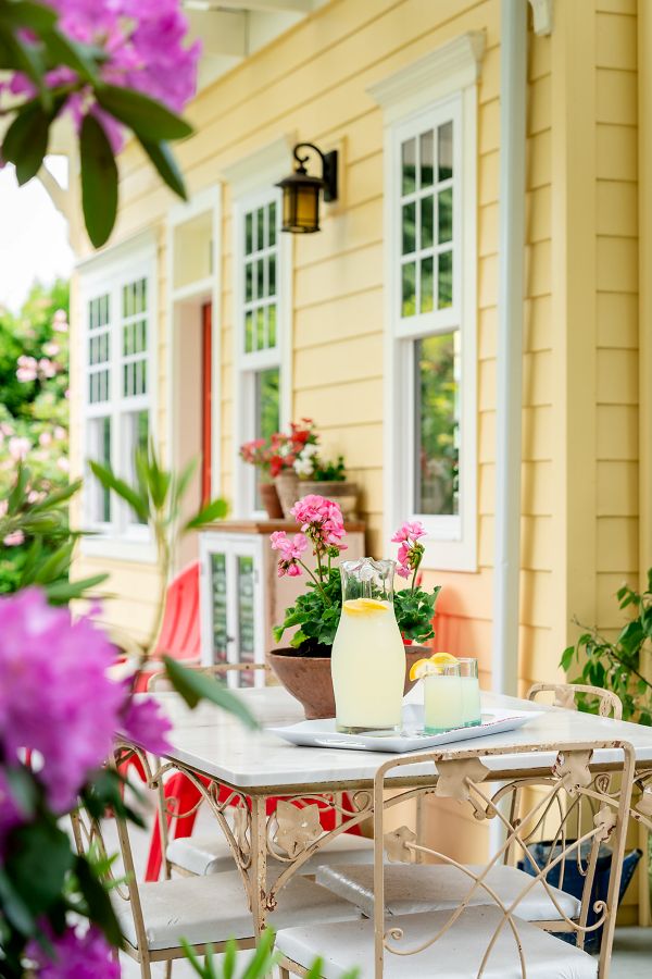 Dining table with flowers and lemonade sitting on covered porch right off the kitchen