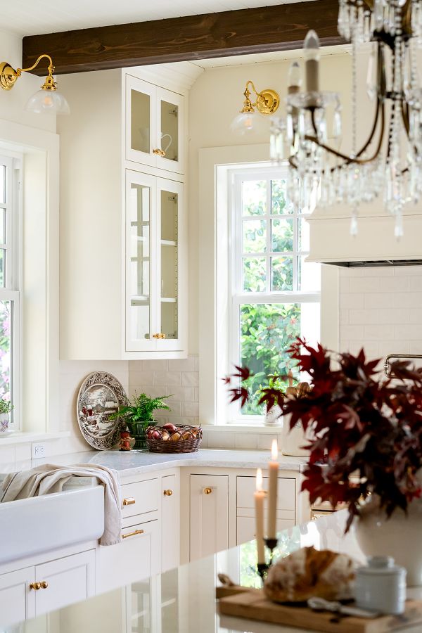 Elegant kitchen cabinetry in cream with glass fronts, highlighting a collection of white dinnerware.
